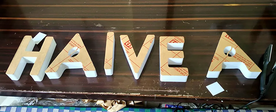 Row of cut 3D letters with protective film still on, ready for finishing
