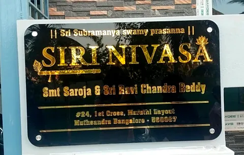 Siri Nivasa house name board: black acrylic with gold lettering on a gate pillar
